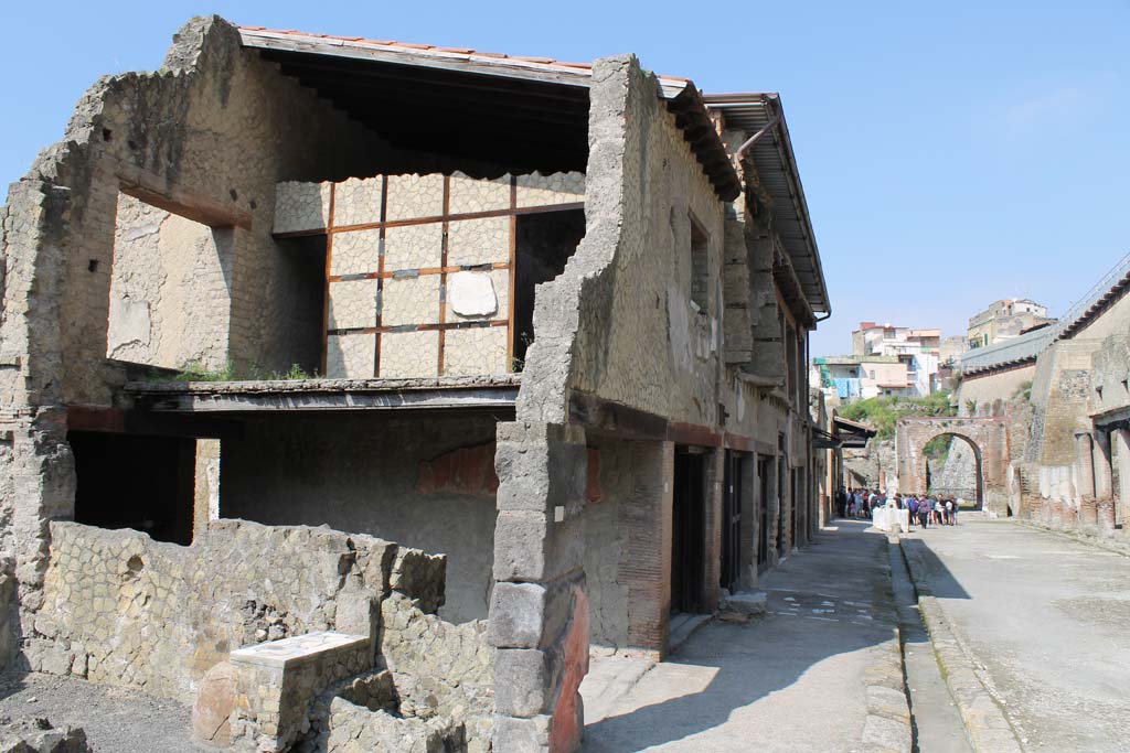 V. 20/19, Herculaneum, March 2014.  
Looking west from north end of insula, across V.21 to rooms on upper floor of V.20 with doorways into upper V.19 set into the framework of the wall. Decumanus Maximus is on the right.
Foto Annette Haug, ERC Grant 681269 DÉCOR.
According to Wallace-Hadrill, a dossier of Cominius Primus was found in this upper apartment.
See Wallace-Hadrill, A. (2011). Herculaneum, Past and Future. London, Frances Lincoln Ltd., (p.257).